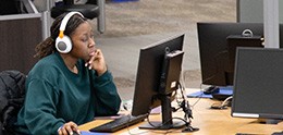 foto: Estudiante con auriculares trabajando en una computadora de la biblioteca